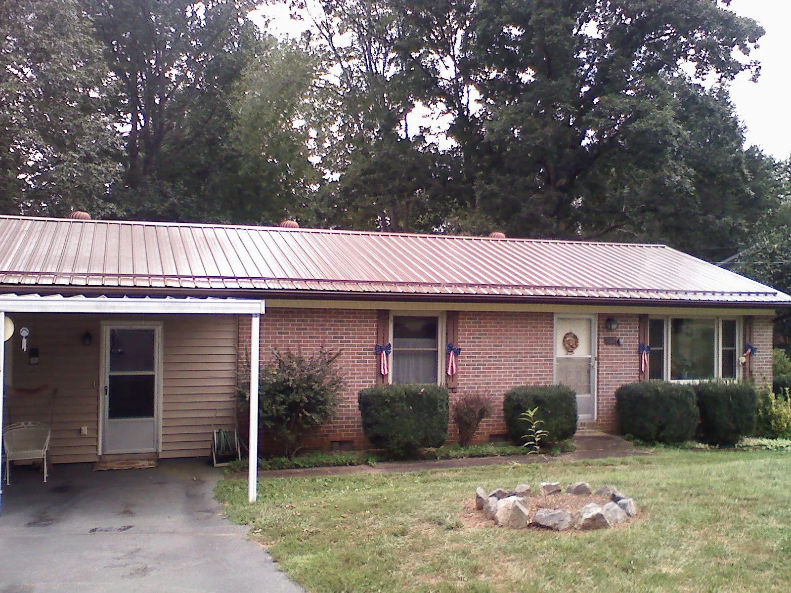 Bronze metal roof and carport on a brick ranch home — Roof Repair work by our crew in Washburn